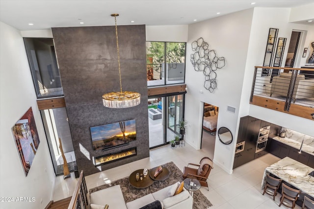 tiled living room with a fireplace, a towering ceiling, and an inviting chandelier