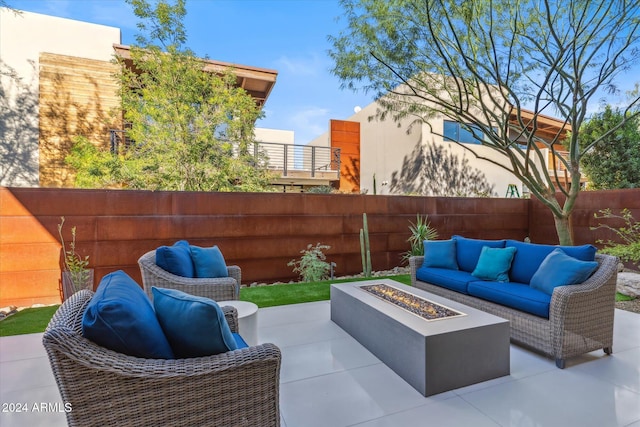 view of patio with an outdoor living space with a fire pit