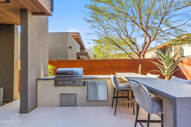 view of patio / terrace featuring an outdoor kitchen, exterior bar, and grilling area