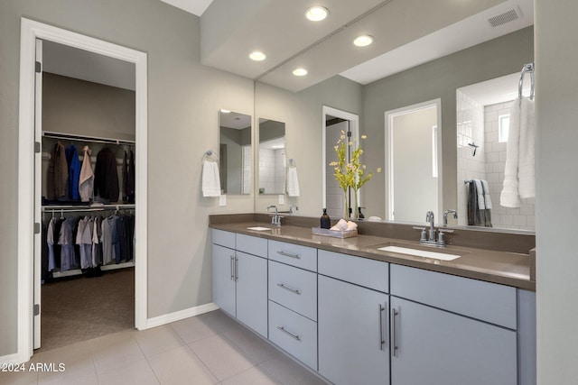 bathroom featuring double vanity, a spacious closet, visible vents, and a sink