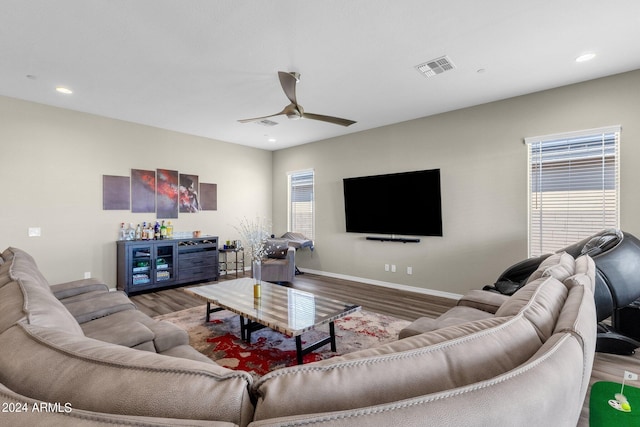 living room featuring plenty of natural light, wood finished floors, visible vents, and baseboards