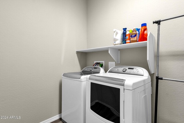 clothes washing area with laundry area, baseboards, and washing machine and clothes dryer