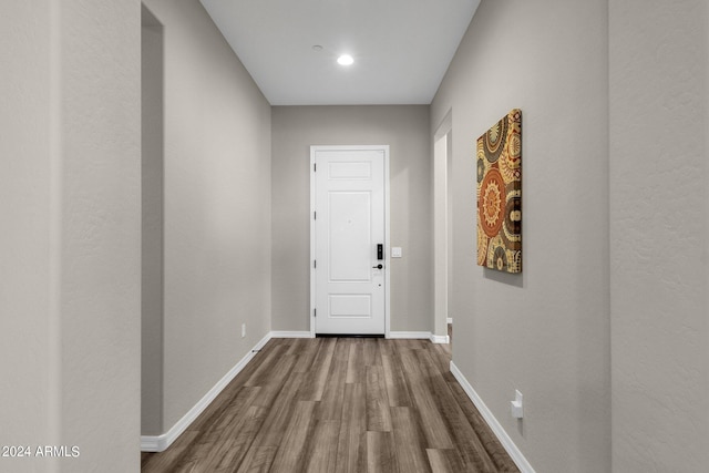 corridor featuring wood finished floors and baseboards