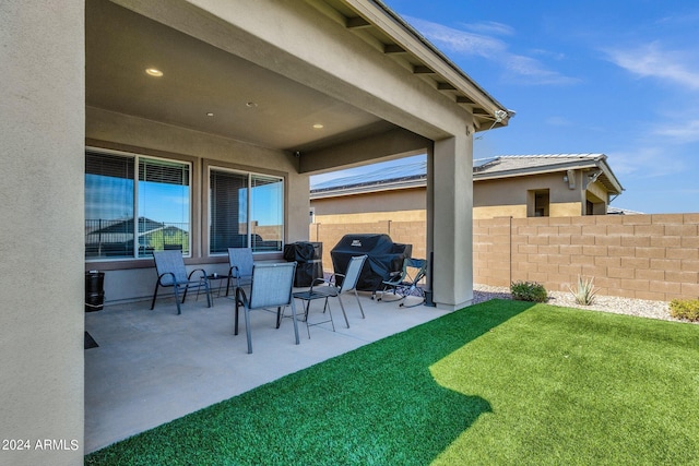 view of patio featuring a grill and fence