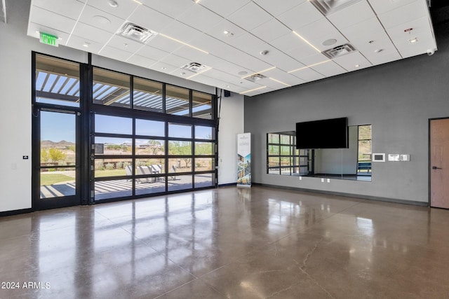 spare room with a towering ceiling, baseboards, and visible vents