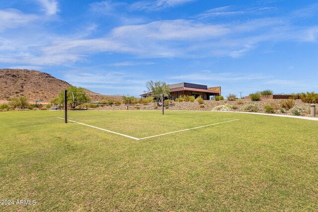 surrounding community with volleyball court and a mountain view