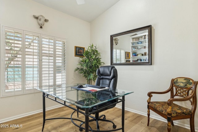 home office with baseboards and wood finished floors