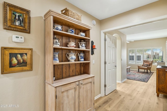 hall featuring baseboards and light wood-style floors