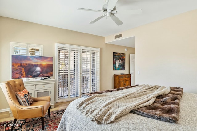 bedroom featuring wood finished floors, ceiling fan, and visible vents