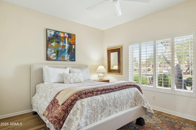 bedroom with baseboards, wood finished floors, and a ceiling fan