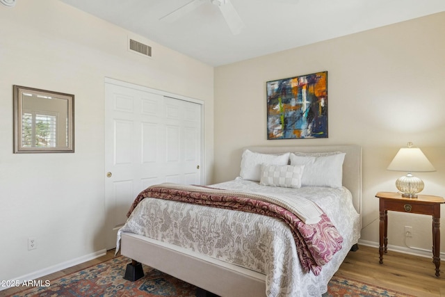 bedroom with baseboards, visible vents, wood finished floors, and ceiling fan
