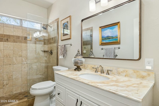 bathroom featuring toilet, vanity, and walk in shower