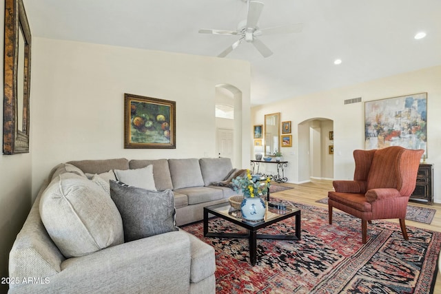 living area with light wood-style flooring, visible vents, recessed lighting, a ceiling fan, and arched walkways