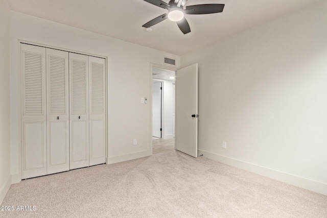 unfurnished bedroom with a closet, ceiling fan, and light colored carpet