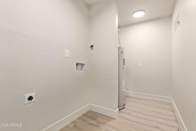 clothes washing area with hookup for a washing machine, water heater, light hardwood / wood-style flooring, and hookup for an electric dryer