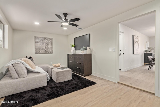 living room featuring light wood-type flooring and ceiling fan