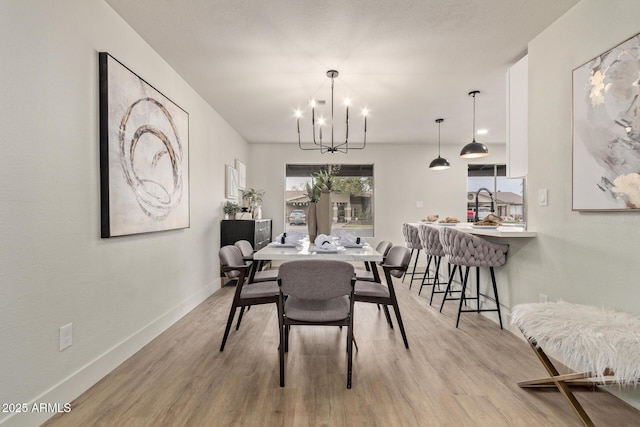 dining space featuring light hardwood / wood-style floors and a chandelier