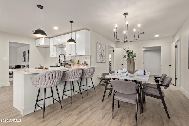 dining area featuring an inviting chandelier and light hardwood / wood-style flooring