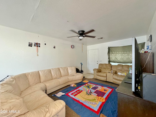 living room with a textured ceiling and ceiling fan