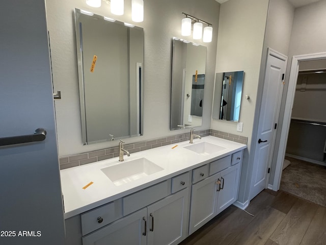 9987 W Verde Ln, Avondale, AZ 85392 - full bath with double vanity, decorative backsplash, a sink, and wood finished floors