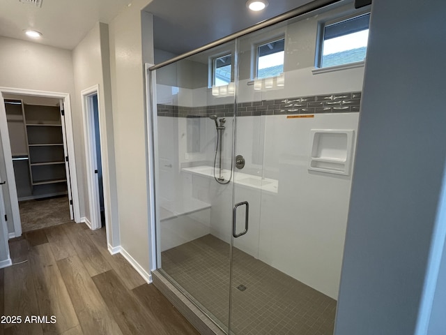9987 W Verde Ln, Avondale, AZ 85392 - bathroom with a stall shower, a walk in closet, wood finished floors, and recessed lighting