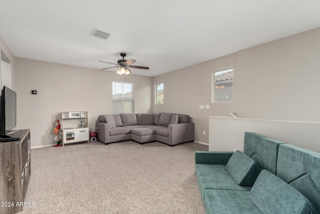 carpeted living room with ceiling fan