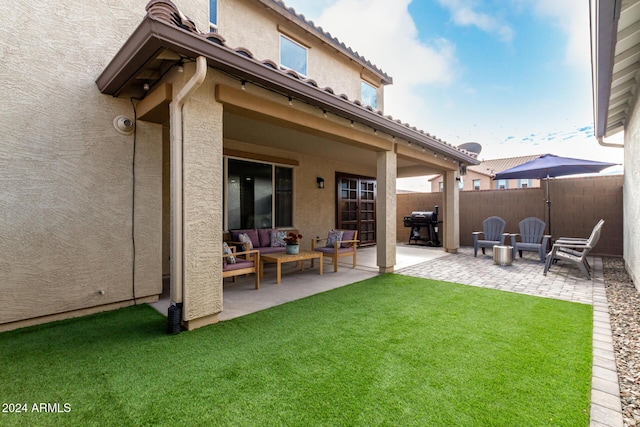 rear view of property with a lawn, a patio area, and an outdoor hangout area