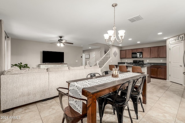 tiled dining room featuring ceiling fan with notable chandelier