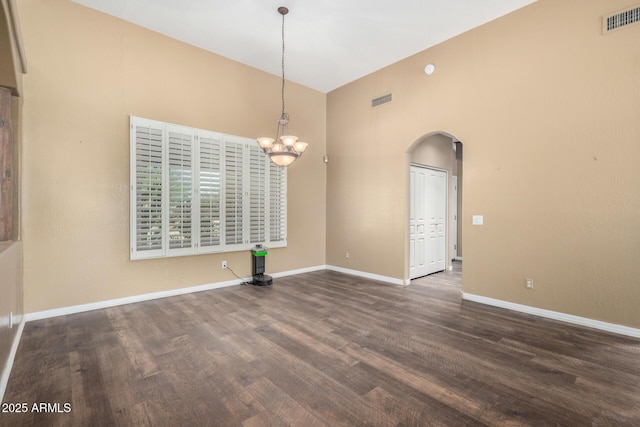 unfurnished dining area with dark wood-type flooring and a notable chandelier