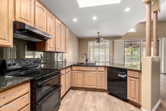 kitchen featuring dark stone countertops, sink, black appliances, and kitchen peninsula