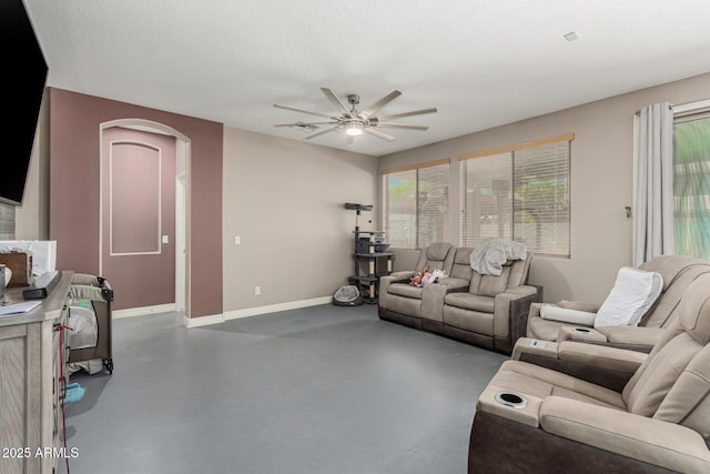 14604 W Banff Ln, Surprise, AZ 85379 - living room with finished concrete flooring, ceiling fan, arched walkways, and baseboards