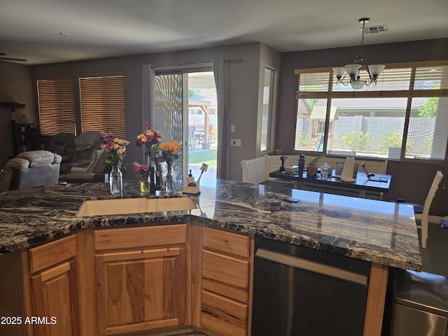 14604 W Banff Ln, Surprise, AZ 85379 - kitchen with open floor plan, a chandelier, dishwasher, brown cabinetry, and dark stone counters