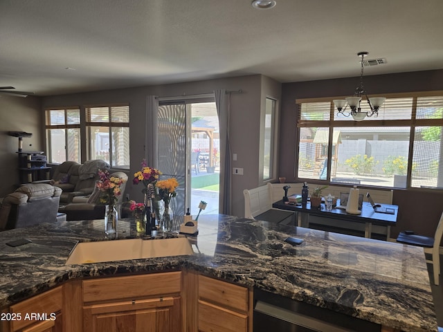 14604 W Banff Ln, Surprise, AZ 85379 - kitchen featuring healthy amount of natural light, a chandelier, open floor plan, and hanging light fixtures
