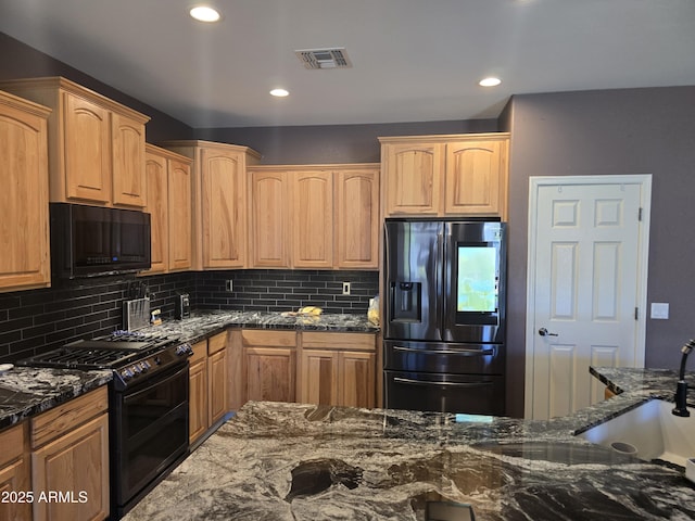 14604 W Banff Ln, Surprise, AZ 85379 - kitchen with black appliances, dark stone counters, tasteful backsplash, recessed lighting, and light brown cabinetry