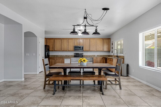 dining area featuring sink and light tile patterned floors