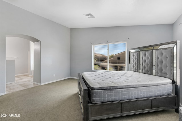 bedroom with lofted ceiling and light colored carpet