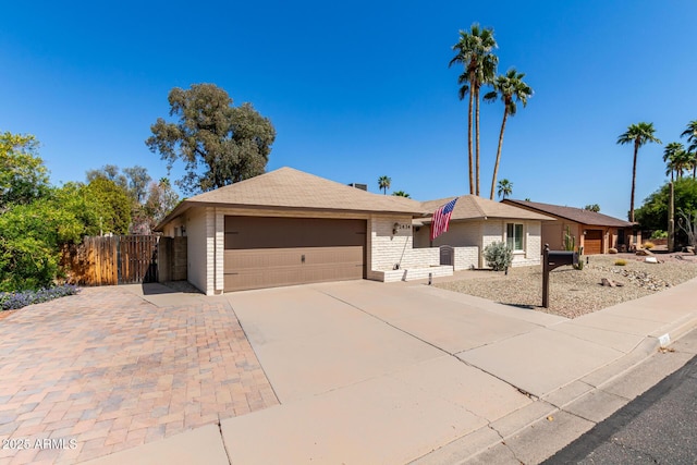 ranch-style house with concrete driveway, a garage, and fence