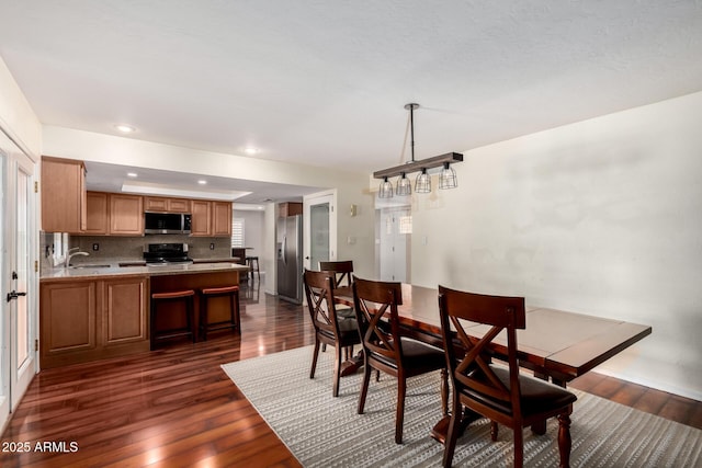 dining space with dark wood-type flooring and recessed lighting