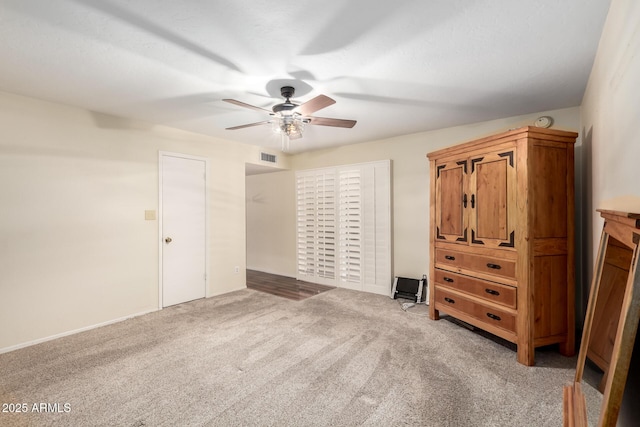 unfurnished bedroom with visible vents, light colored carpet, and a ceiling fan