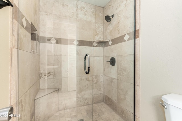 bathroom featuring a shower stall and toilet