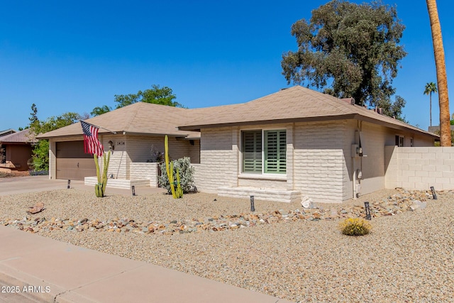 ranch-style home with concrete driveway, an attached garage, and fence