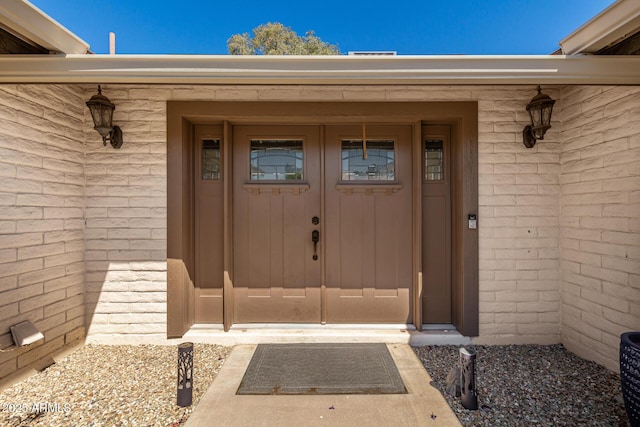 doorway to property with brick siding
