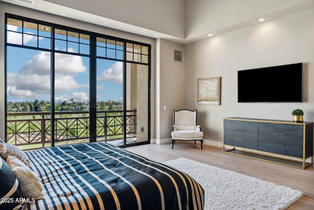 bedroom with access to exterior, wood finished floors, baseboards, and recessed lighting