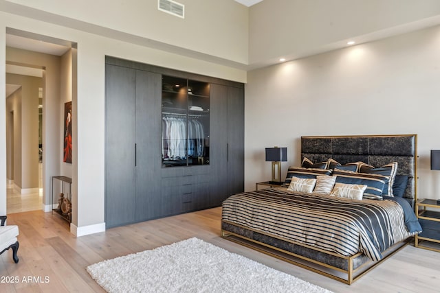 bedroom featuring a closet, light wood finished floors, and baseboards