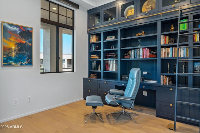 office with wood finished floors, built in desk, and baseboards