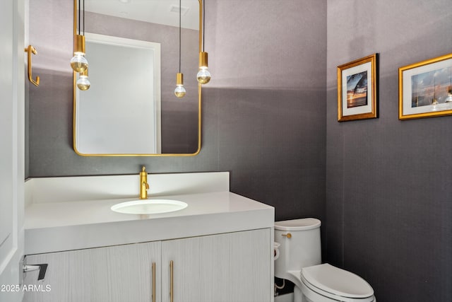 half bathroom with vanity and toilet