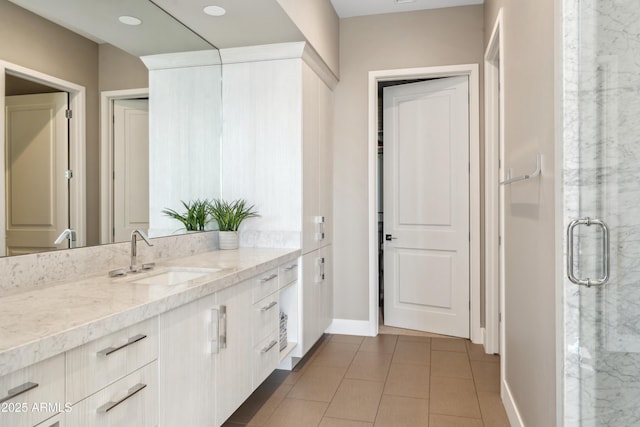 bathroom with vanity, baseboards, a stall shower, and tile patterned flooring