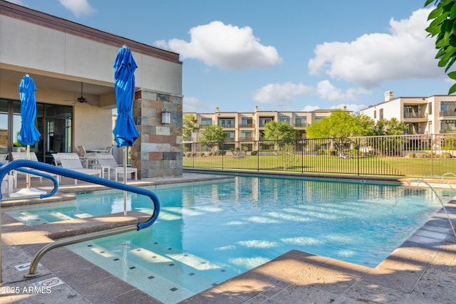 community pool with a patio area, fence, and a ceiling fan