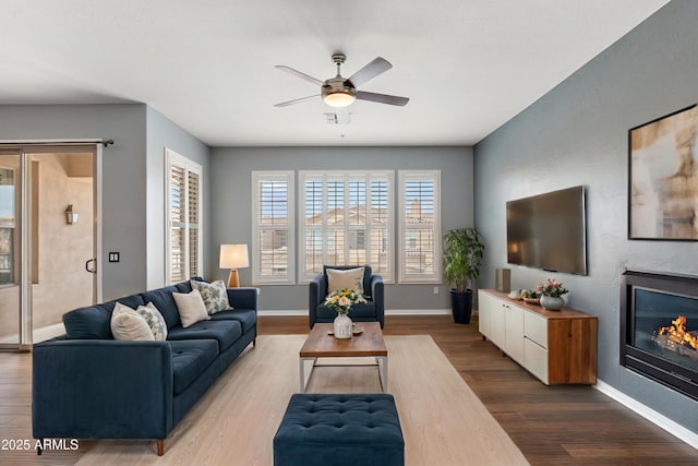 19475 N Grayhawk Dr Unit 2151, Scottsdale, AZ 85255 - living room with wood finished floors, a ceiling fan, a large fireplace, and baseboards