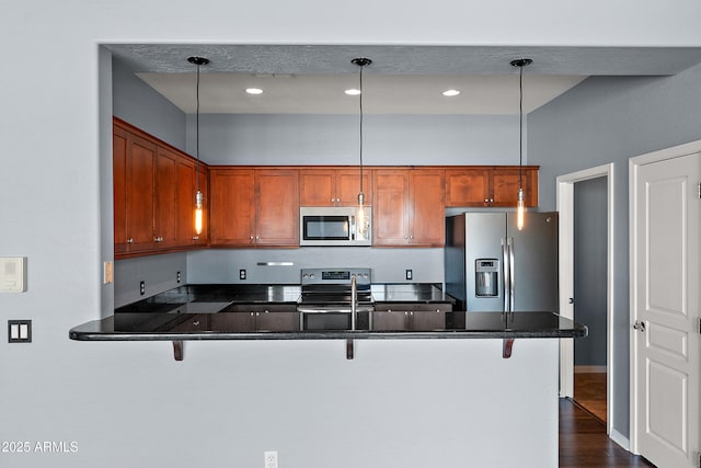 19475 N Grayhawk Dr Unit 2151, Scottsdale, AZ 85255 - kitchen with stainless steel appliances, a peninsula, a breakfast bar area, and dark wood-style flooring